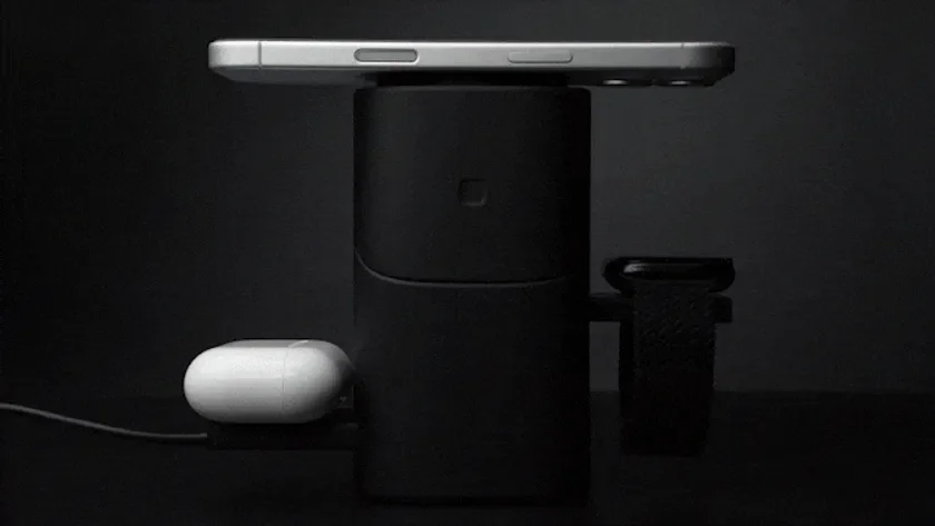 暗い背景に置かれた多機能ワイヤレス充電器で、スマートフォン、ワイヤレスイヤホンケース、スマートウォッチが同時に充電されている様子を捉えた画像です。