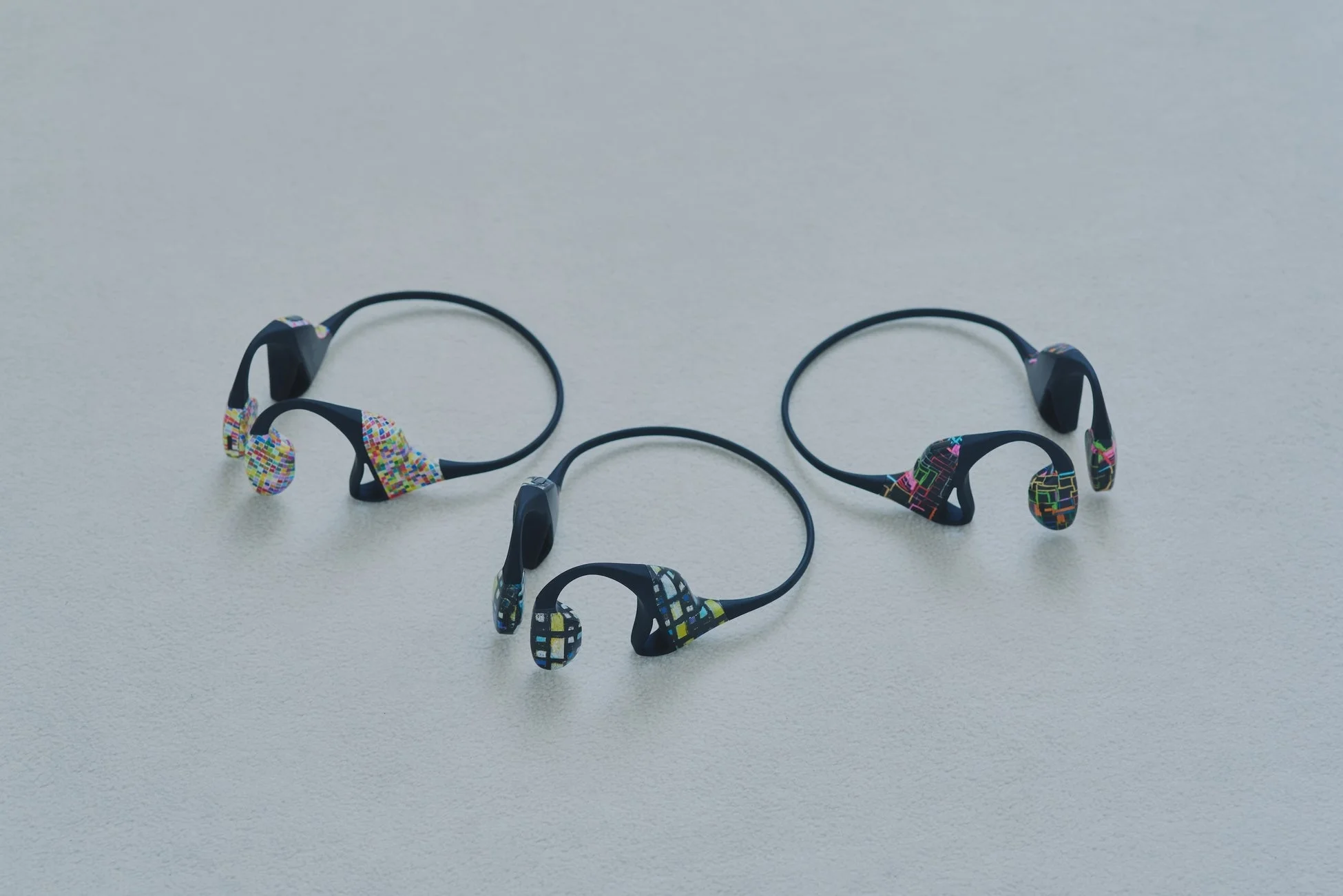 カラフルなモザイク柄の3つの骨伝導ワイヤレスヘッドホン