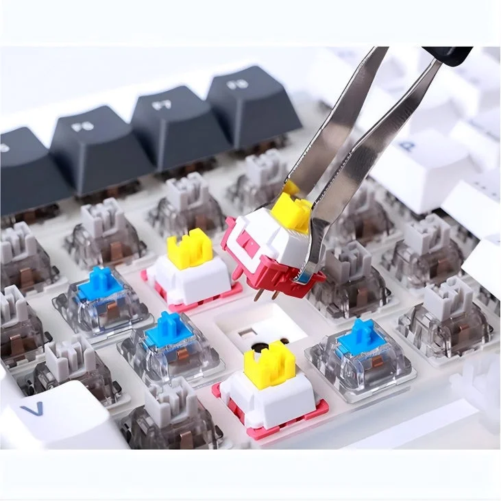 メカニカルキーボードからピンセットを使ってキースイッチを取り外している様子